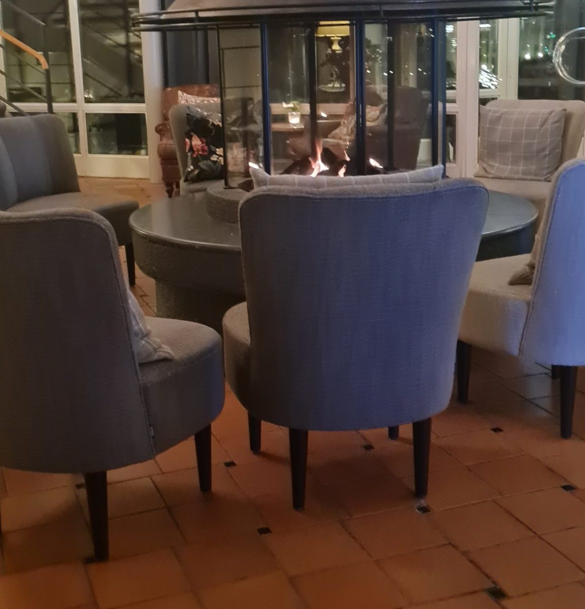 Här kan man sitta och mysa framför en öppen brasa. Brasan höll hela lokalen varm. Detta är i receptionen där man kan koppla av med lite fika.